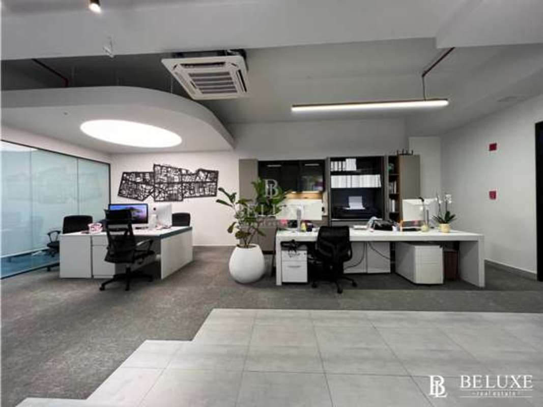 Glass enclosed conference room white chairs wall TV modern decor Panama City