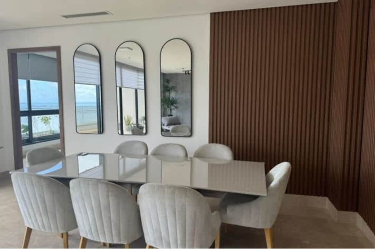 Contemporary dining area with glass table, black chairs, large corner windows with skyline view in PH Mirador Costa del Este Panama
