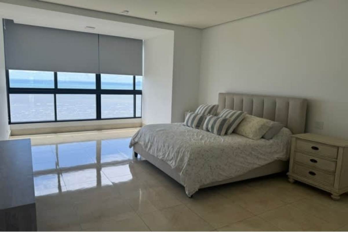 Minimalist bedroom with upholstered bed, large window with ocean view, neutral tones, PH Mirador Costa del Este Panama