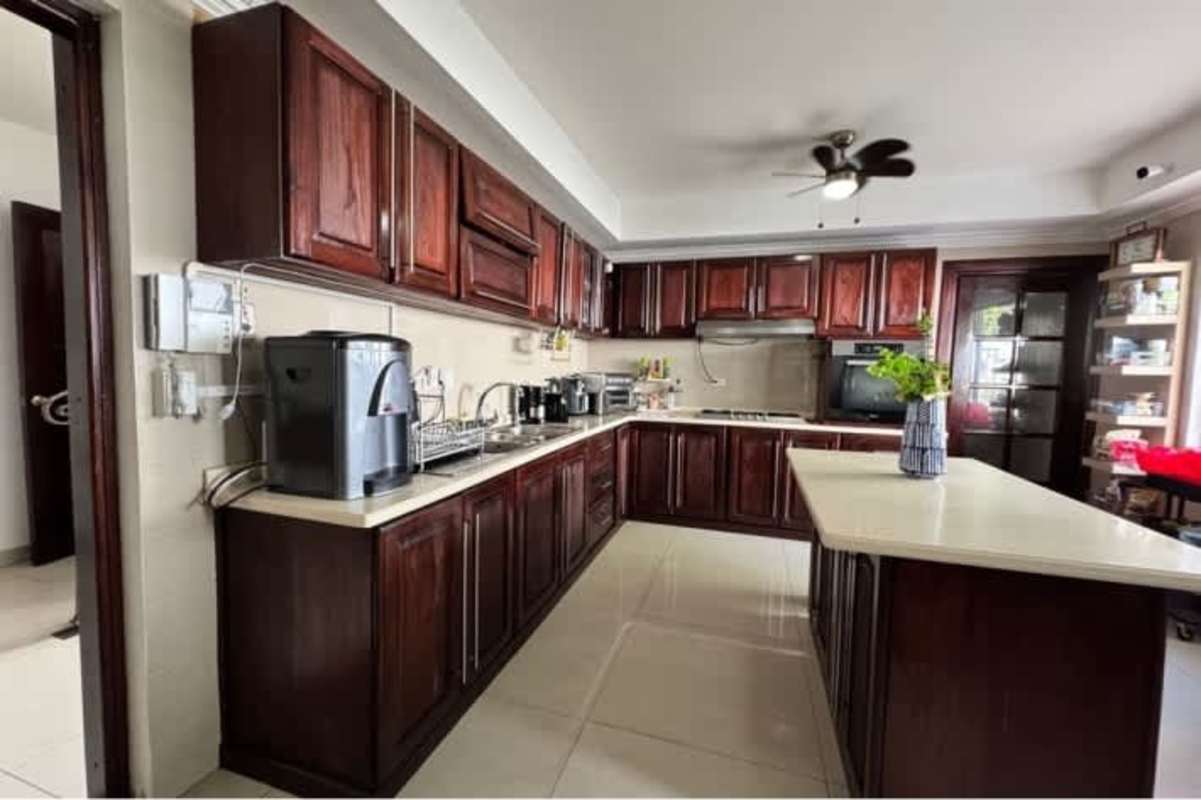 Large kitchen with wood cabinetry and island in luxury home Altos del Golf Panama