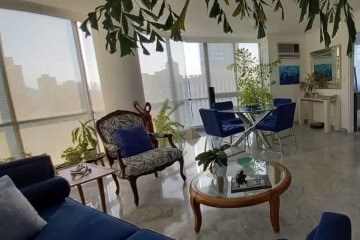 Open-concept contemporary apartment interior with blue furniture and city views in El Cangrejo Panama City
