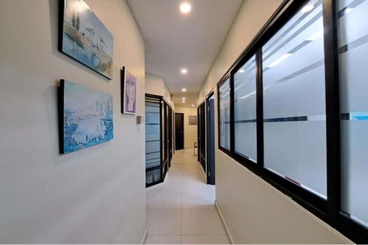 Corporate office corridor with glass walls and artwork PH Banco General Tower Marbella Panama