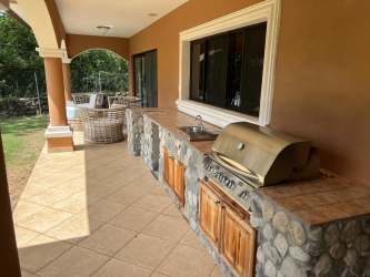 Stone outdoor kitchen with built-in grill and covered patio in Alto Boquete luxury residence