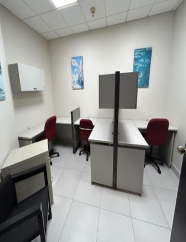 Partitioned office workstations with red chairs and artwork in Torre Banco General Panama