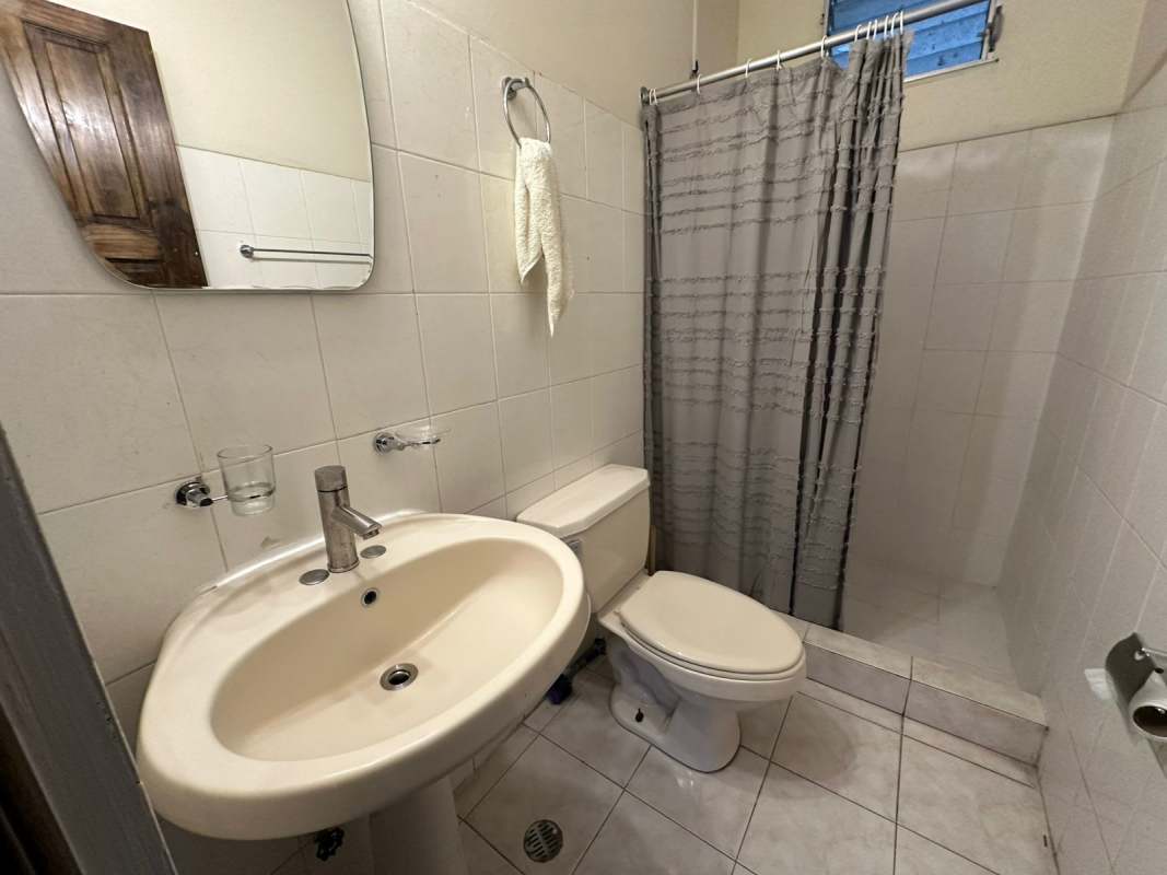 Simple bathroom with tiled walk-in shower, pedestal sink in PH Las Roccas Altos de Panama