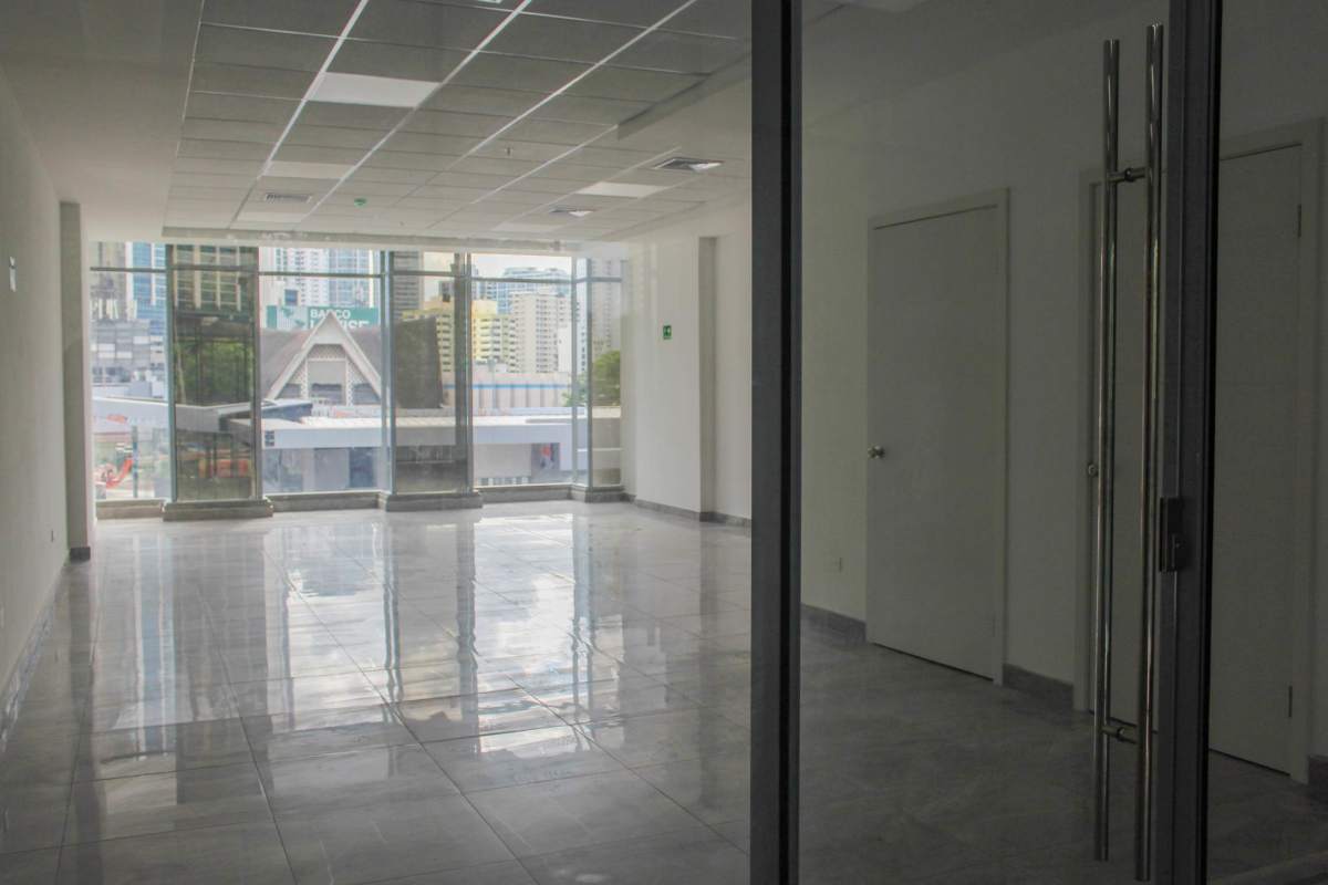 Floor-to-ceiling window in bright office space overlooking Panama City skyline at Sunset Strip Plaza