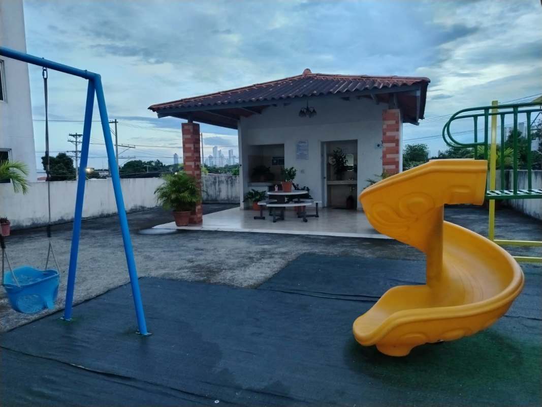 Children's playground with slides and swings on rooftop common area at PH Parque Lefevre Panama City