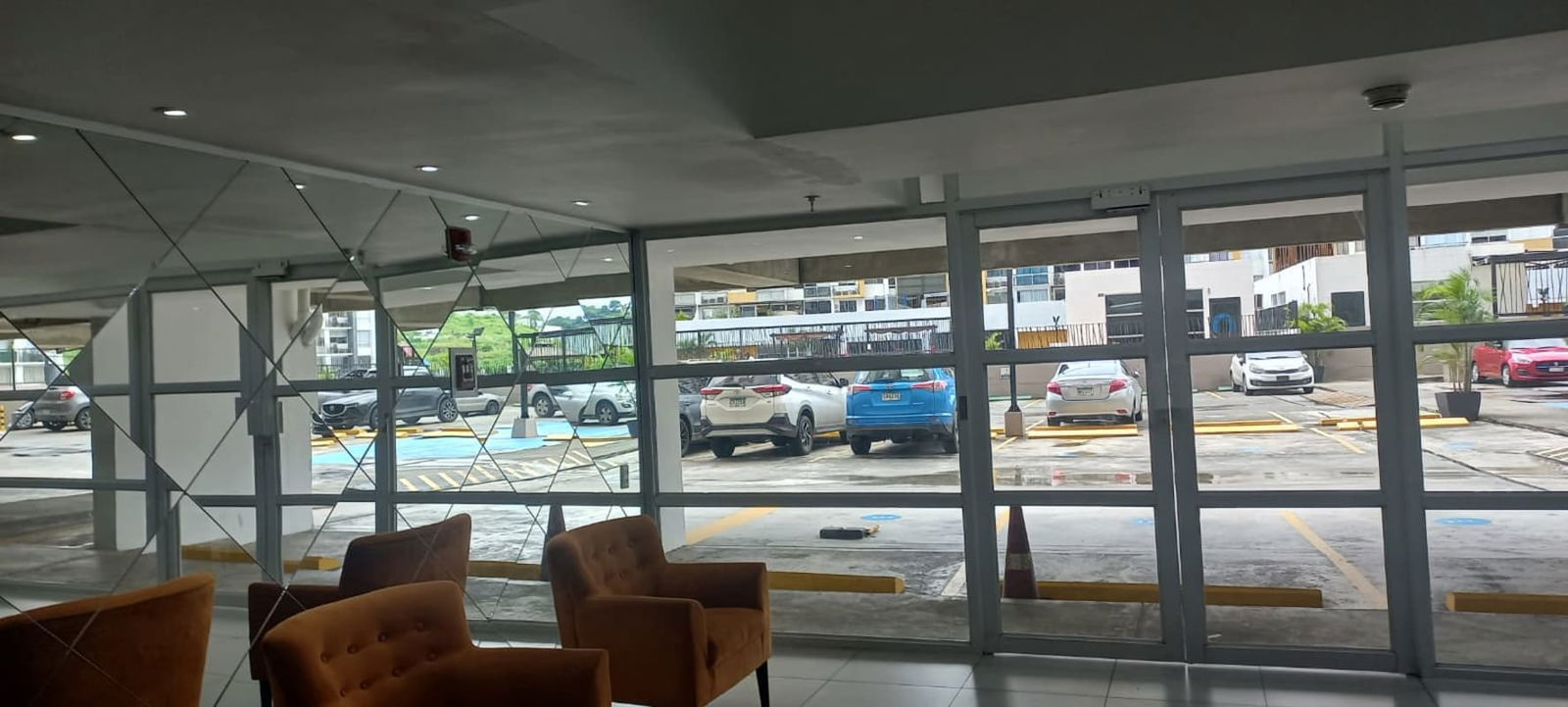 Lobby area with glass wall overlooking parking in PH Aviñon Panama