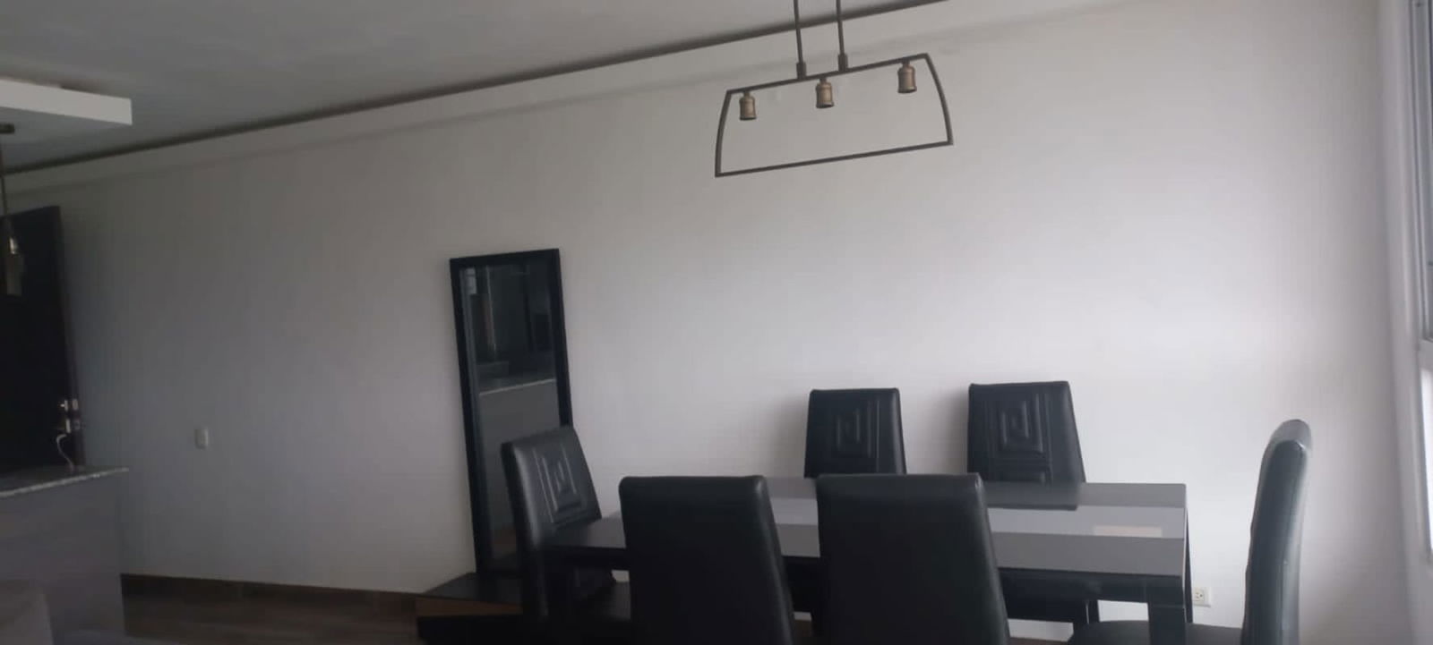 Minimalist dining room with glass table and black chairs PH Aviñon Panama