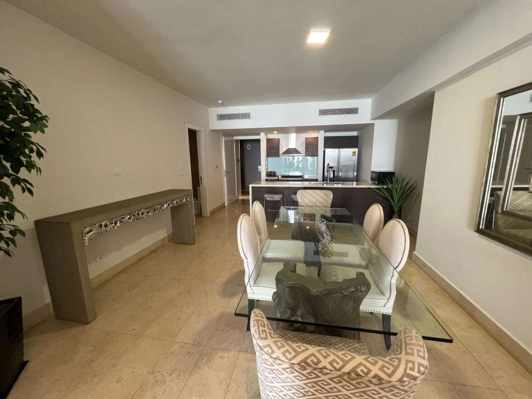 Contemporary dining room with glass table and view of modern kitchen in Yoo Panama