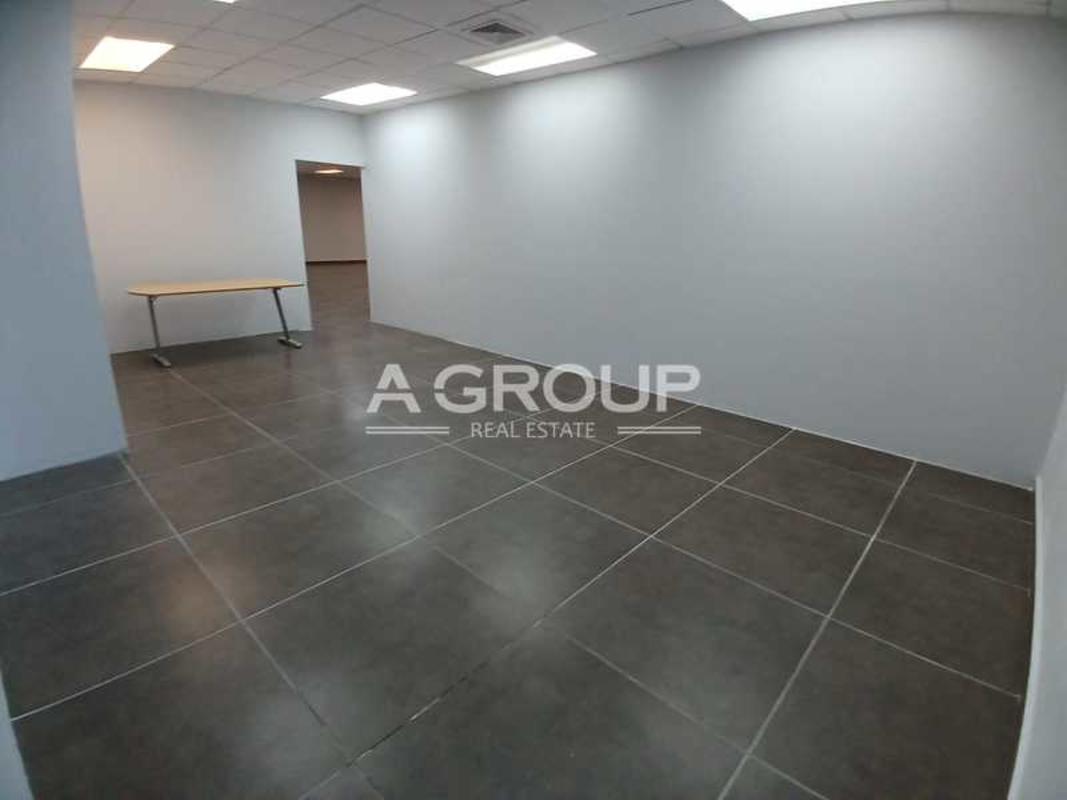 Modern office with glass partitions and tiled floor at ELMEC Panama City