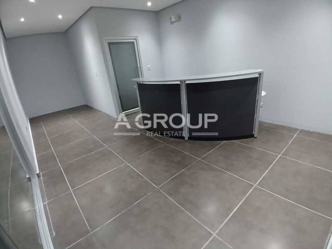 Commercial hallway with glass office windows, tiled floors at Edificio ELMEC Panama City