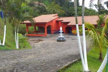 Private swimming pool with waterfall feature surrounded by tropical landscaping at Altos del María Panama villa