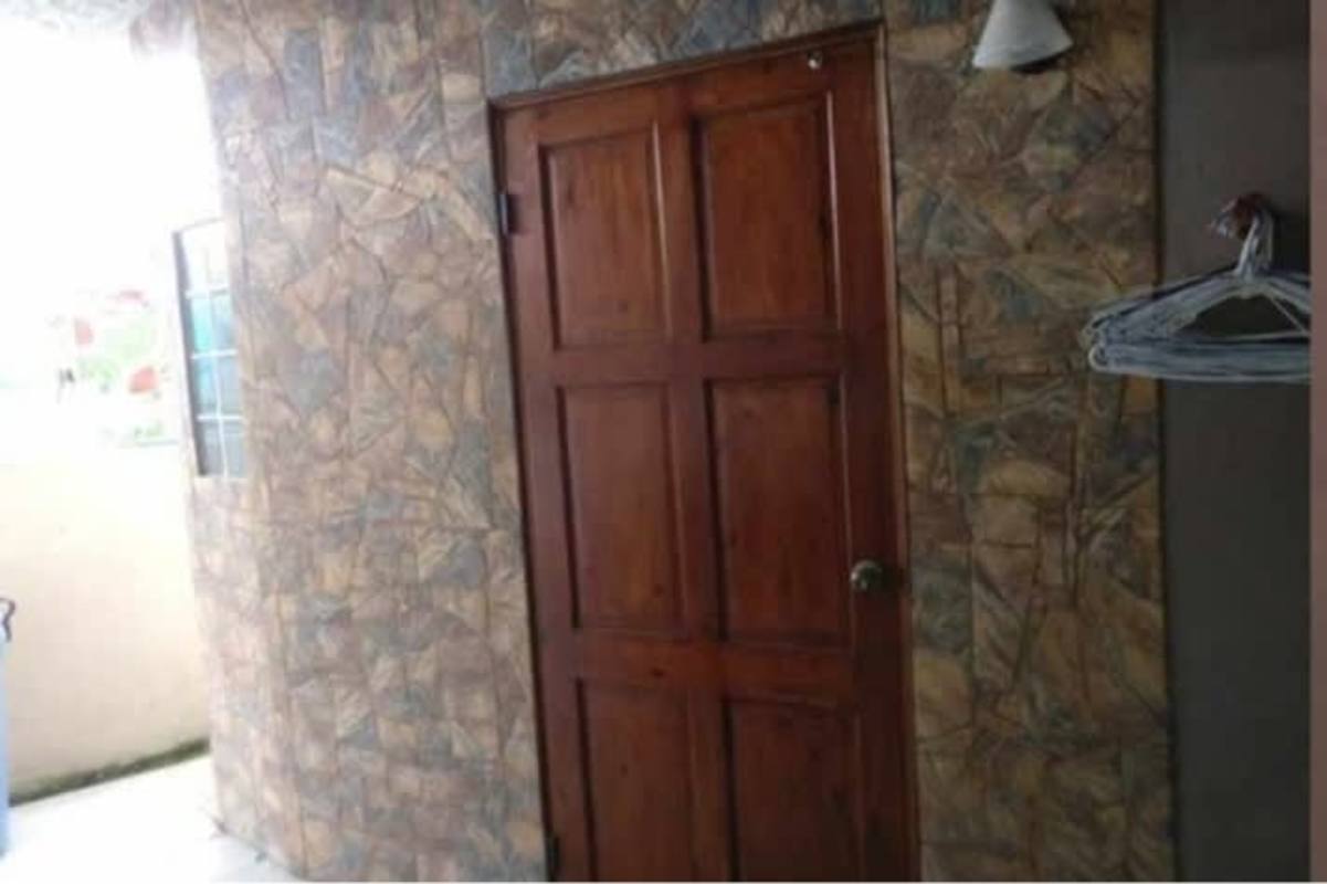 Rustic wooden door with stone pattern wall exterior Cerro Viento house Panama