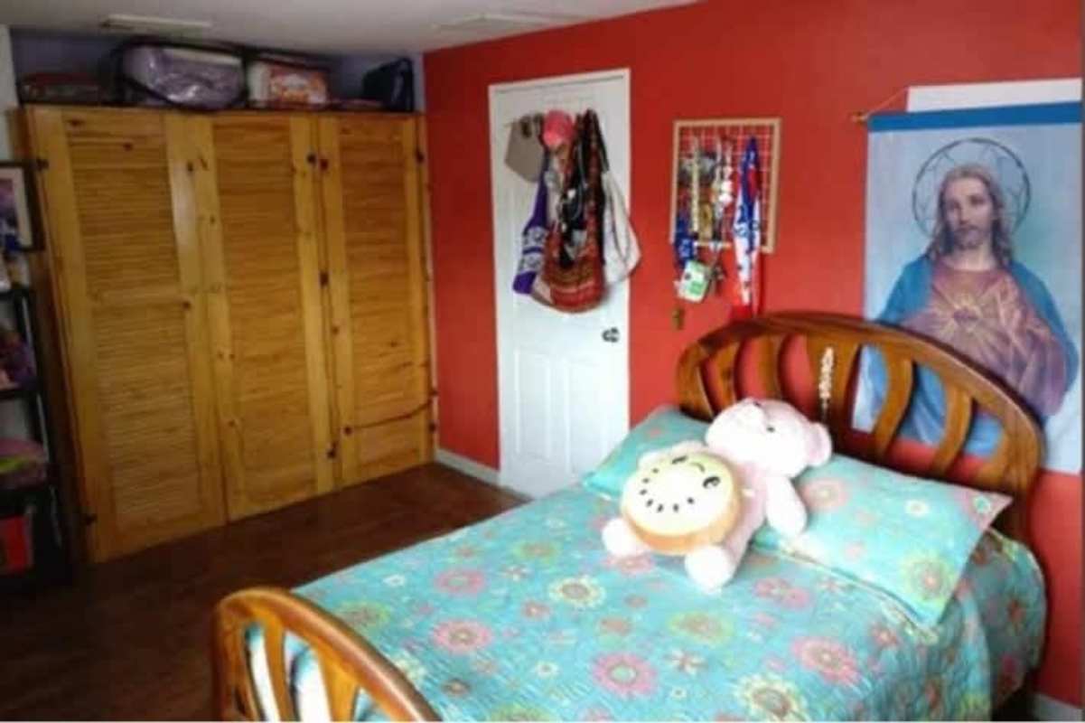 Bedroom with single bed, colorful walls, wardrobe, window in Cerro Viento Panama City