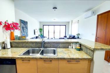 Contemporary kitchen with granite countertops and stainless steel appliances in Altamar Casamar beach apartment San Carlos Panama