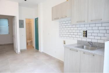 Compact kitchen with subway tile backsplash light cabinetry granite countertop La Quince Santa Ana