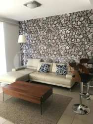 Bedroom with large bed, closet, window and bath access at PH Mosaic Panama Pacifico apartment for rent