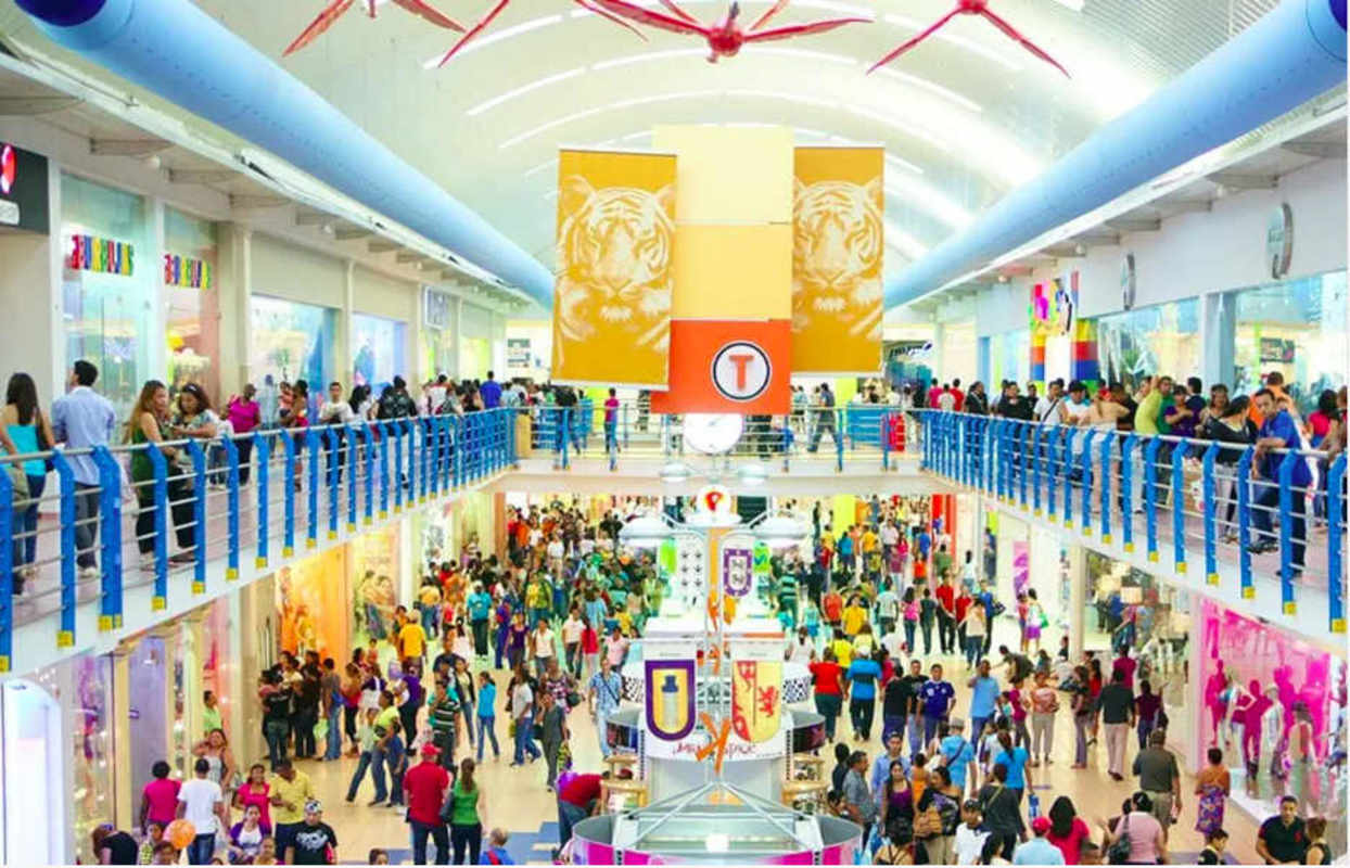 Crowded inside corridor Albrook Mall two levels shops colorful banners Panama