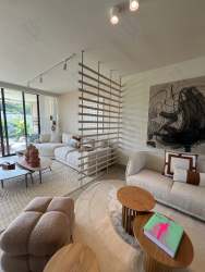 Spacious open kitchen with island, white cabinetry, and marble countertops in Panama Pacifico Howard house