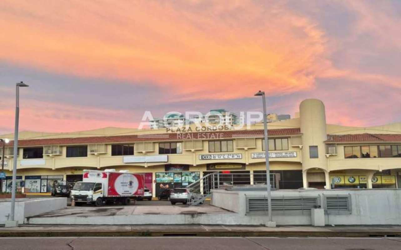 Exterior of Plaza Cordoba shopping center with sunset lighting and visible retail stores in Panama City