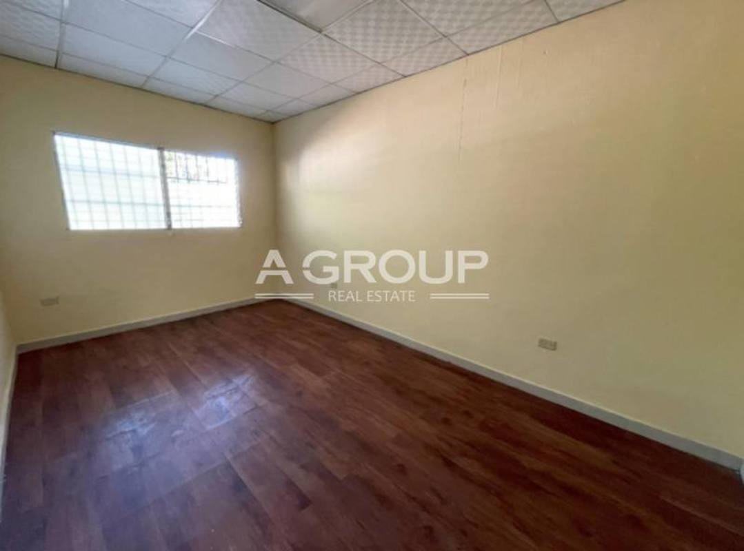 Spacious interior room in commercial warehouse with wood floors and security window Panama City