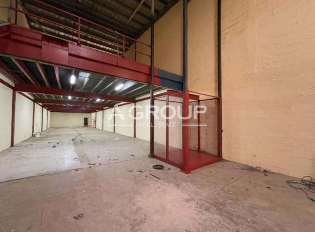 Interior of industrial warehouse with steel mezzanine and fenced red storage area Panama