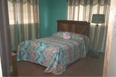 Front facade of single-level house with driveway and mature trees in Lidice Capira Panama Oeste