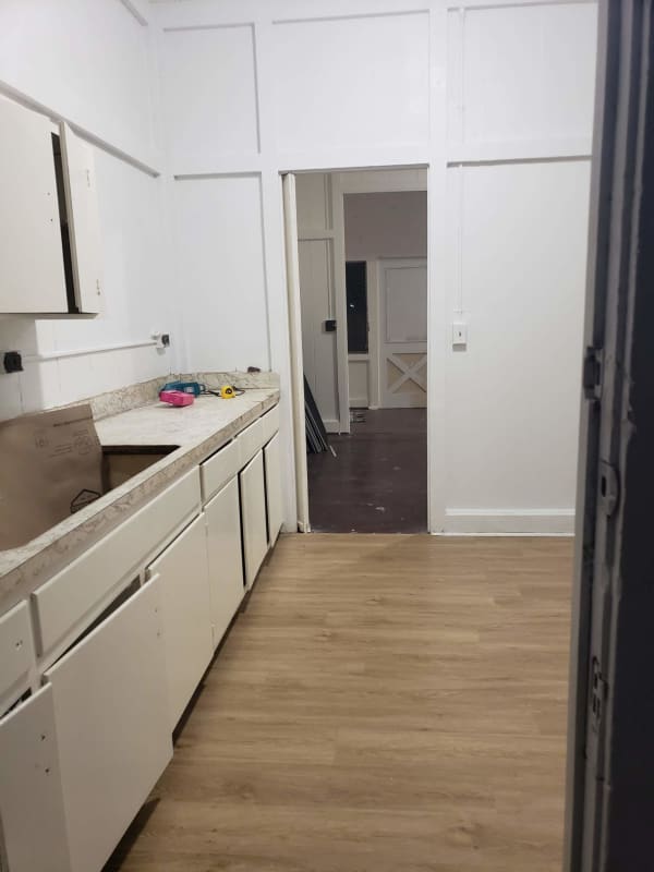 Simple kitchen with white paneled walls and marble pattern countertop near Balboa Panama