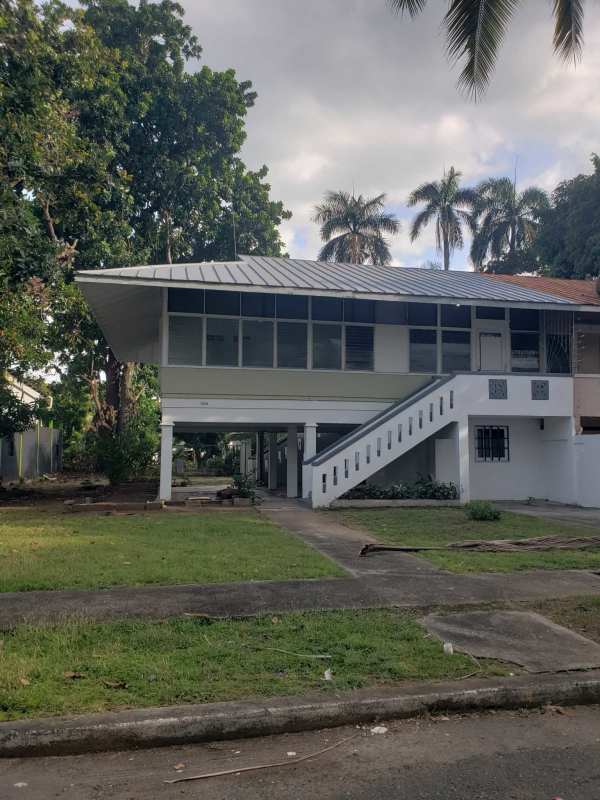 Elevated white tropical house with stairs surrounded by palm trees for rent Balboa Panama