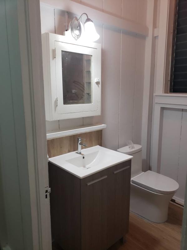 Bathroom with walk-in rainfall shower beige marble tiles duplex rental Balboa Panama