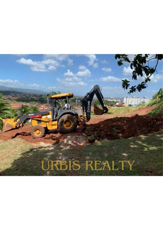 Construction excavator operating on cleared residential and commercial lot in El Crisol metro area Panama