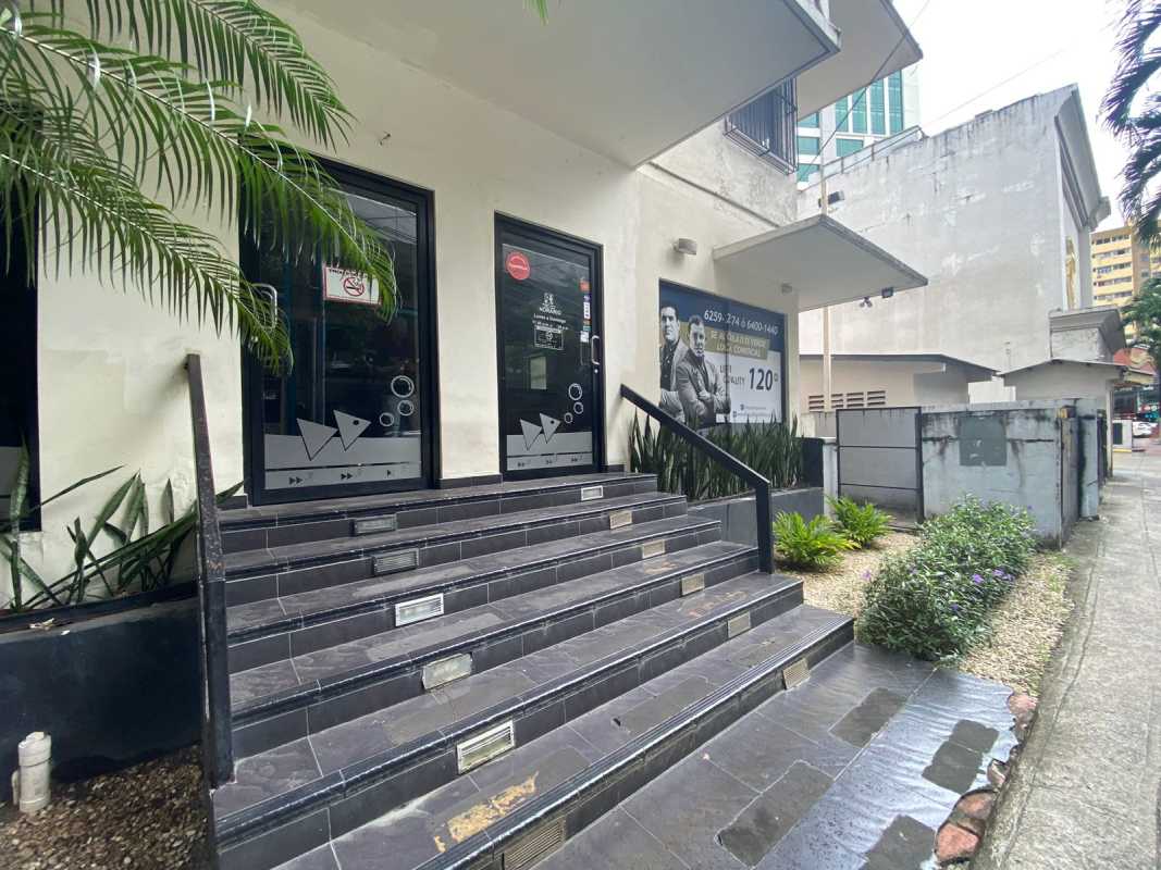 Modern commercial building entrance with glass doors, stairs and signage Calle 50 Obarrio Panama