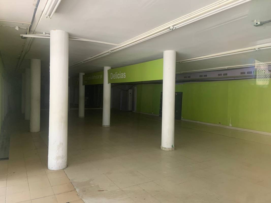 Large retail commercial space with tiled floor, columns, green accent wall and signage Via Argentina Panama