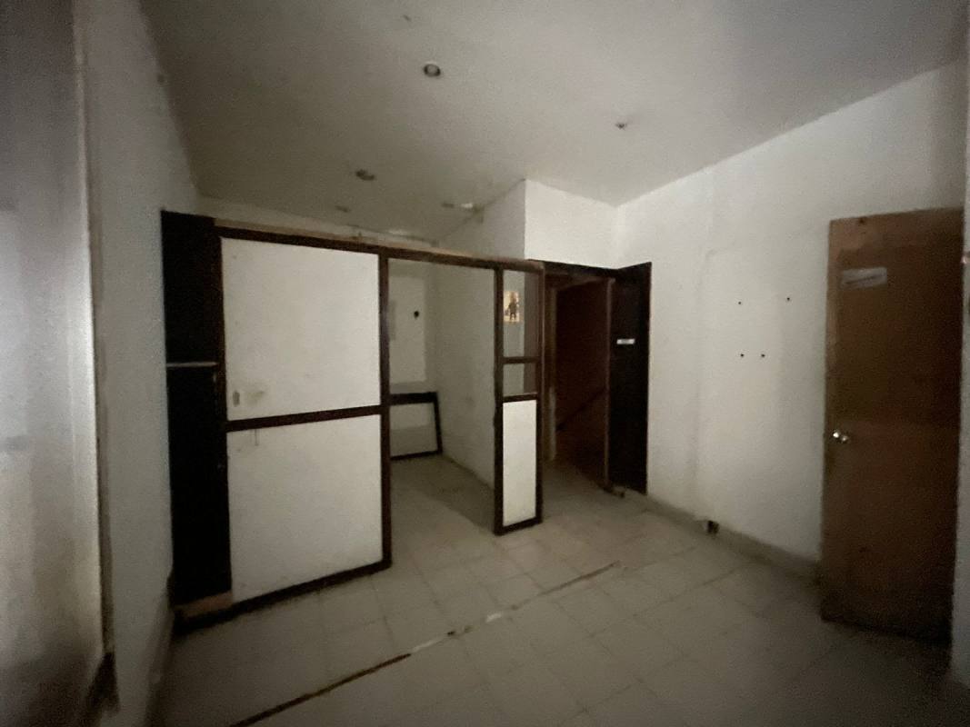 Dim hallway in commercial building with partition wall and tile floor El Cangrejo Panama