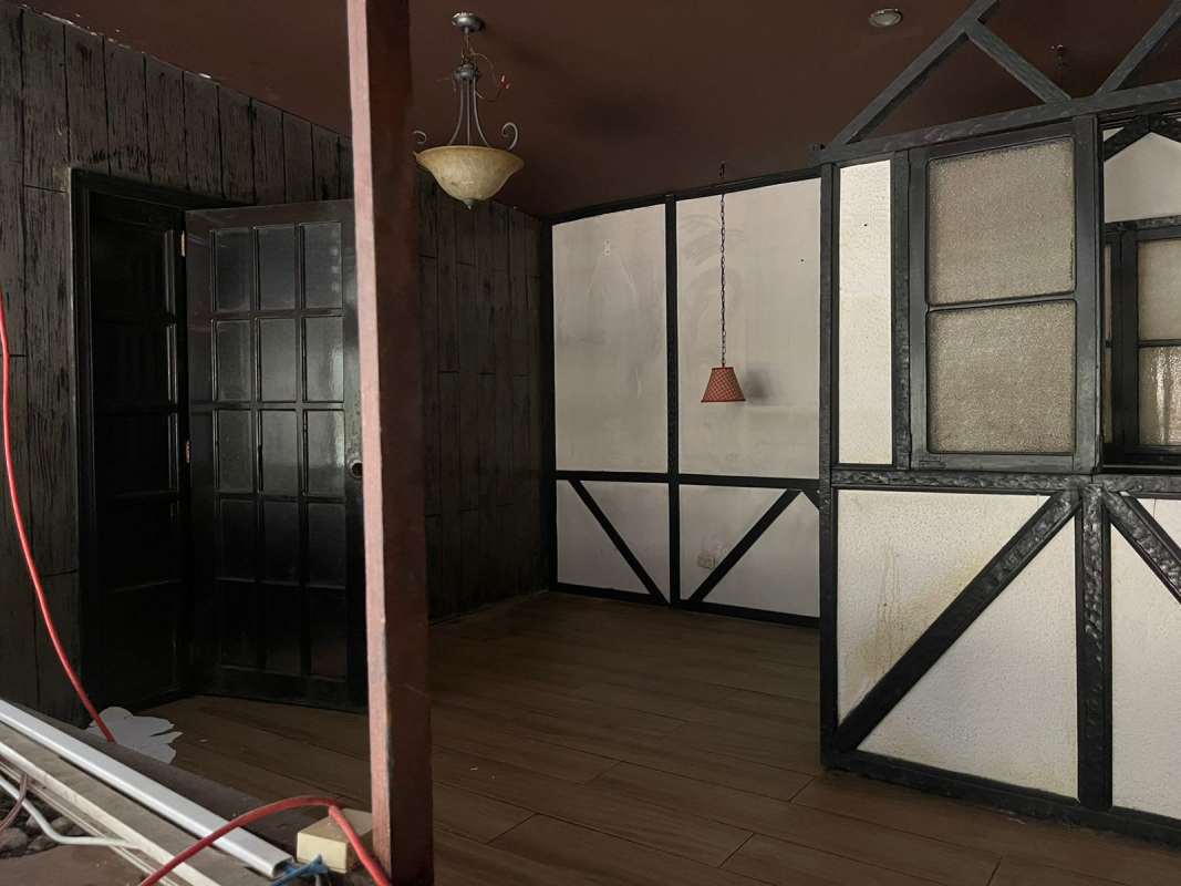 Rustic dining nook with booth seats, brick accent wall and pendant lamps in commercial property El Cangrejo Panama