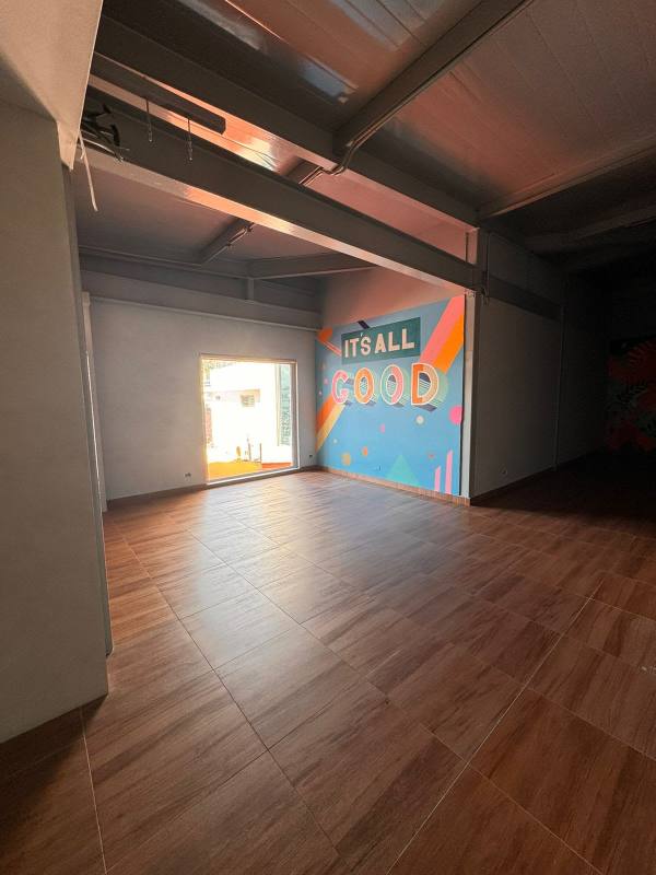 Spacious open plan with wood-like flooring and colorful mural in commercial space Punta Pacífica