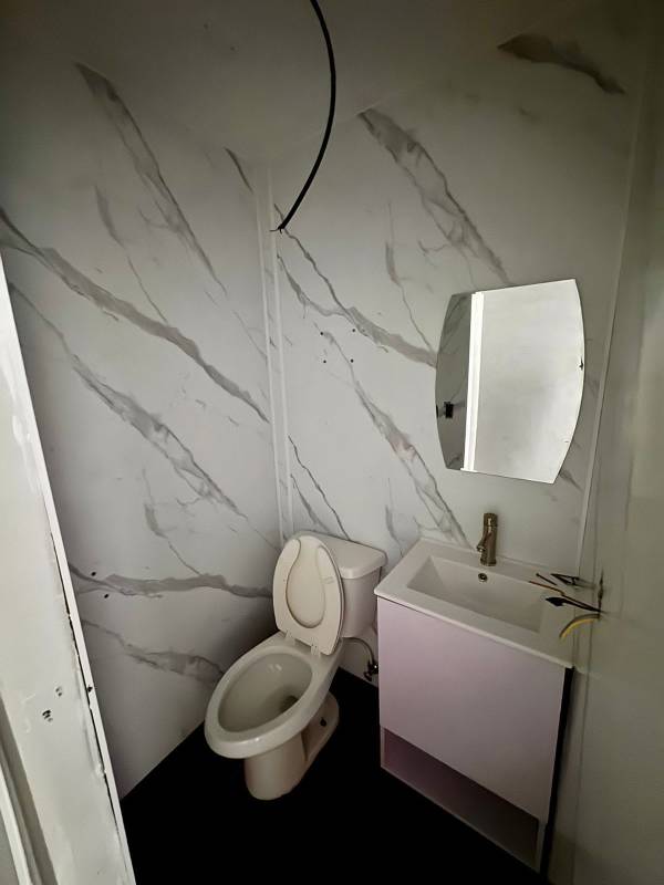Modern bathroom with marble wall tiles and white fixtures in Punta Pacífica