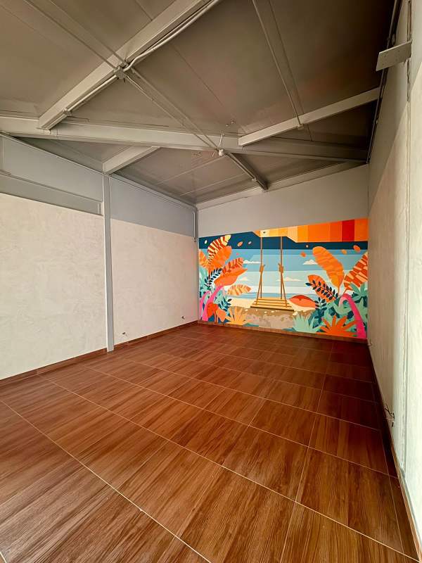 Open area with colorful mural, high ceilings and wood-look tile in commercial plaza Punta Pacífica Panama