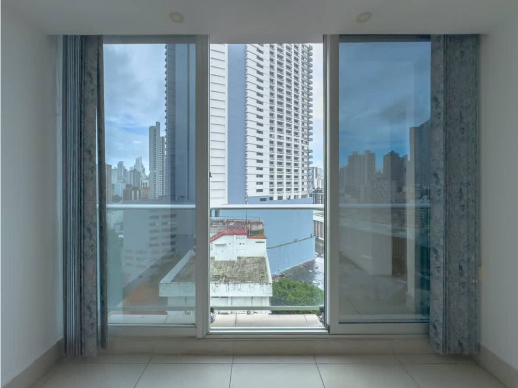 Living room with glass sliding door, balcony access and panoramic city views in Park City Panama