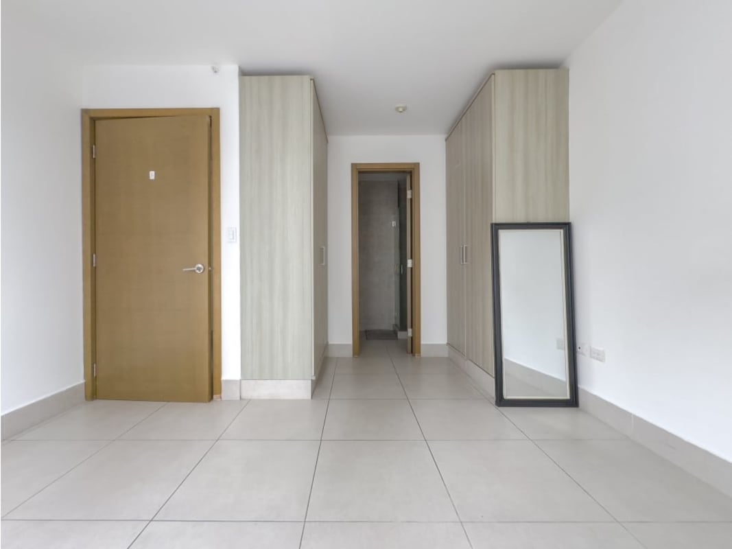 Bedroom with panoramic floor-to-ceiling windows and urban skyline view in Park City Panama