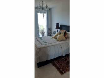 Cozy bedroom with large window opening to balcony at PH Ibiza Playa Corona Panama beachfront condo