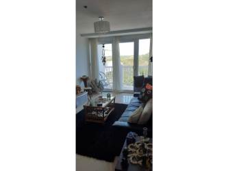 Large bright living room with ocean-facing glass door in Ibiza Playa Corona Panama condo