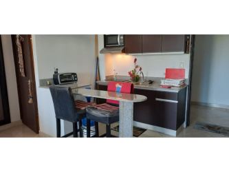 Modern compact kitchen with small breakfast counter at PH Ibiza Playa Corona Panama beachfront condo