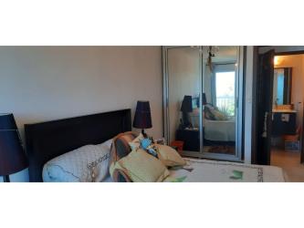 Modern bedroom with mirrored closets and ensuite bathroom in Ibiza Playa Corona condo Panama