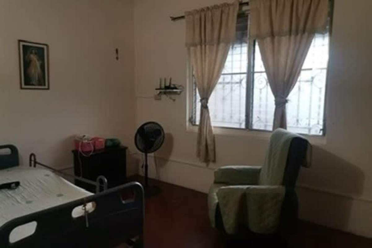 Bedroom with hospital bed, window security bars and basic furnishings in Betania Panama