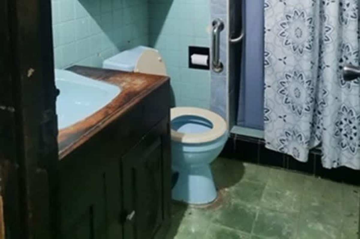 Mid-century bathroom with blue toilet wooden countertop accessibility grab bar Betania house Panama