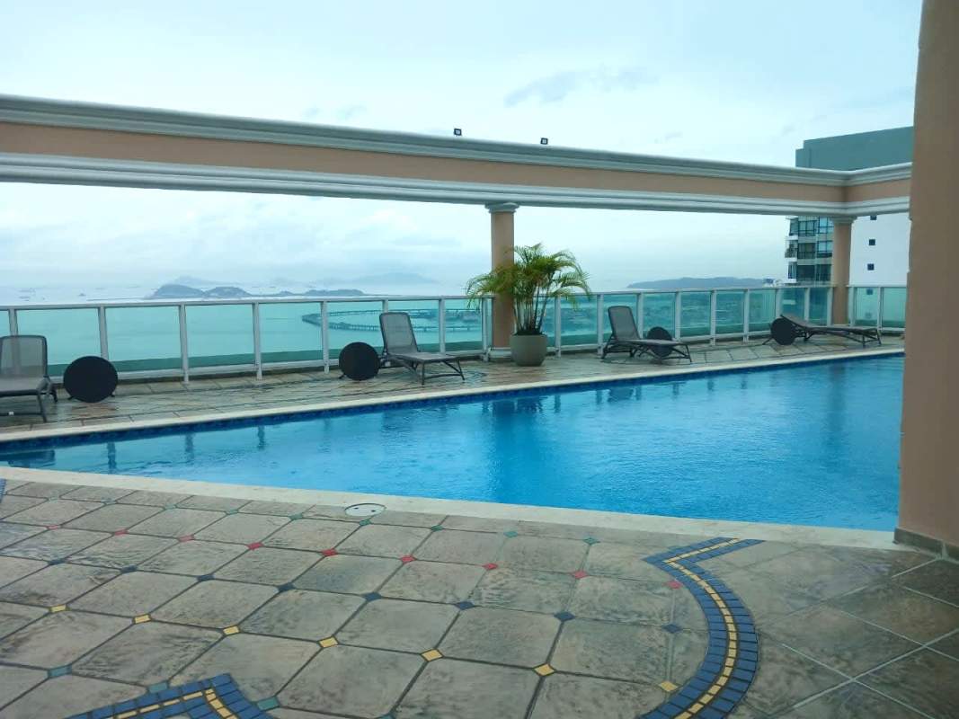 Luxury rooftop pool with lounge chairs glass railing and ocean views at PH Vista Marina Panama City