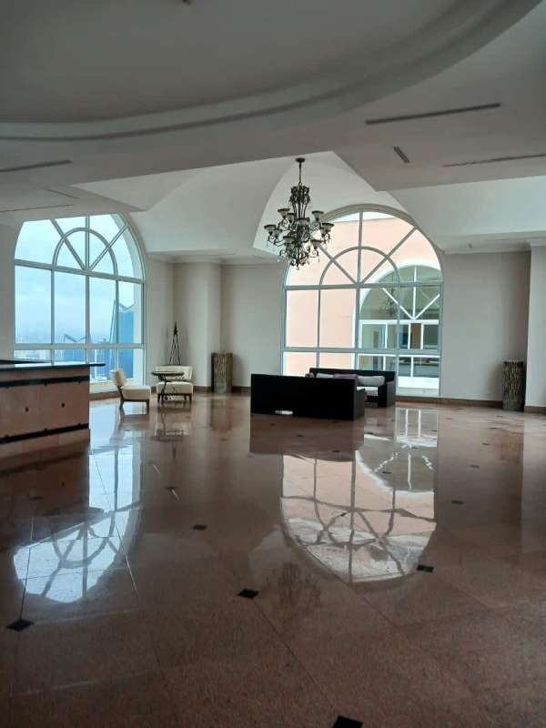 Elegant marble lobby with vaulted ceiling chandeliers and tall arched windows at PH Vista Marina Panama City