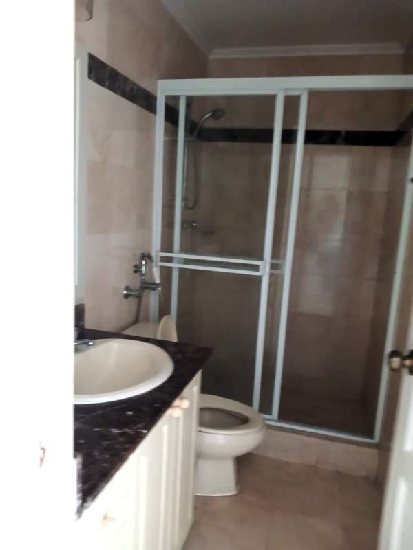 Stylish bathroom featuring glass shower enclosure, marble countertop vanity in Vista Marina tower Panama City